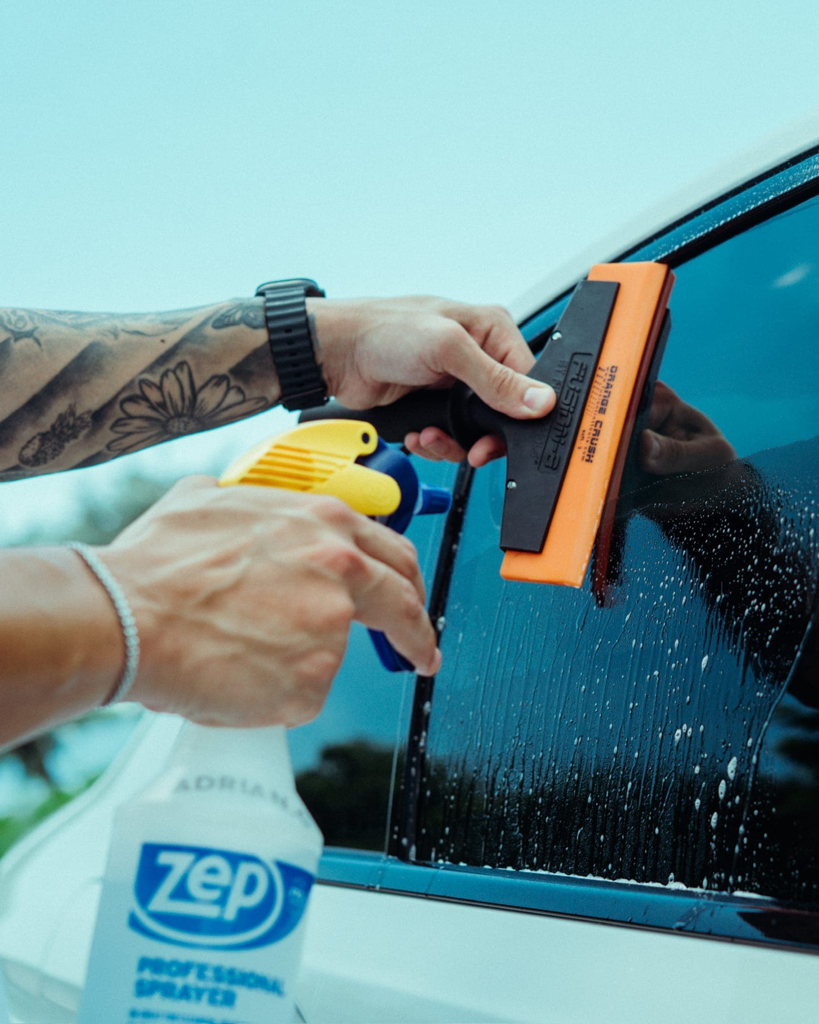 Close-up of a squeegee smoothing freshly applied window film