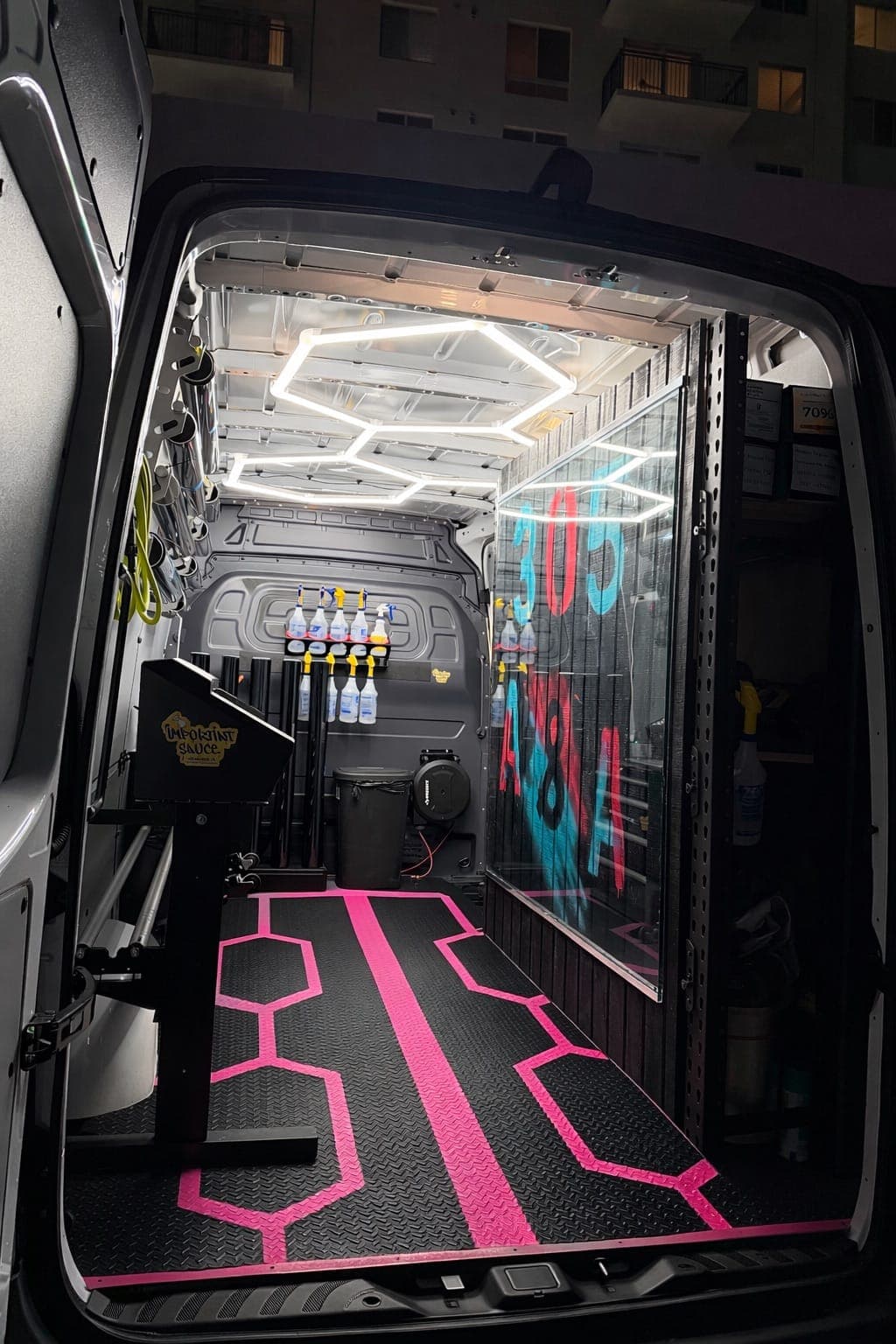 Interior of the mobile tint van with neon hex lighting and film rolls